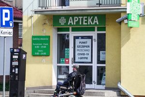 Mężczyzna na wózku przed apteką
